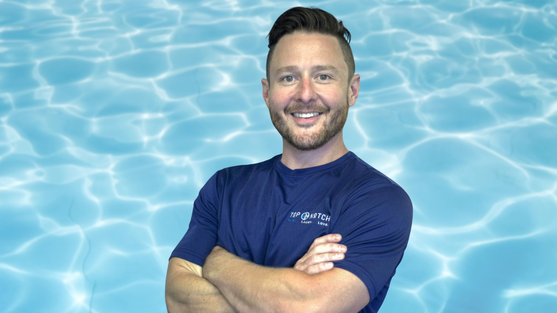 Ronny from Top Notch Pool Management smiling with his arms crossed against a swimming pool water background.